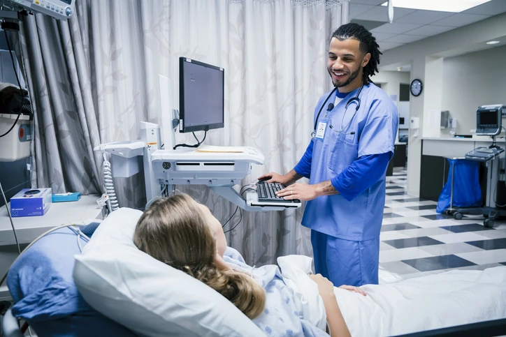 Profissional de enfermagem realizando atendimento humanizado a paciente internada em ambiente hospitalar moderno