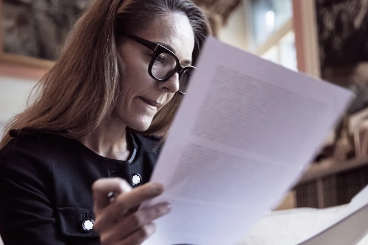 Mulher executiva concentrada lendo documentos importantes em escritório