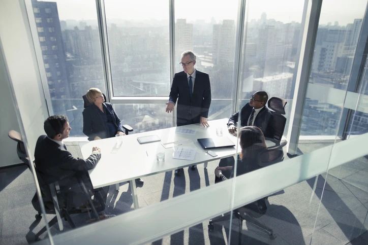 Executivos em reunião de negócios em uma sala de conferência moderna com vista para a cidade