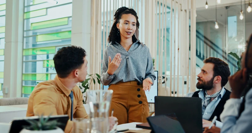 Mulher negra liderando reunião de negócios em escritório moderno com equipe Líder de equipe apresentando ideias em uma reunião de negócios colaborativa em um escritório moderno com profissionais focados