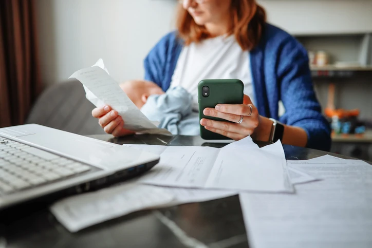 Desafios da maternidade e organização financeira: mãe equilibrando tarefas domésticas e cuidados com o bebê