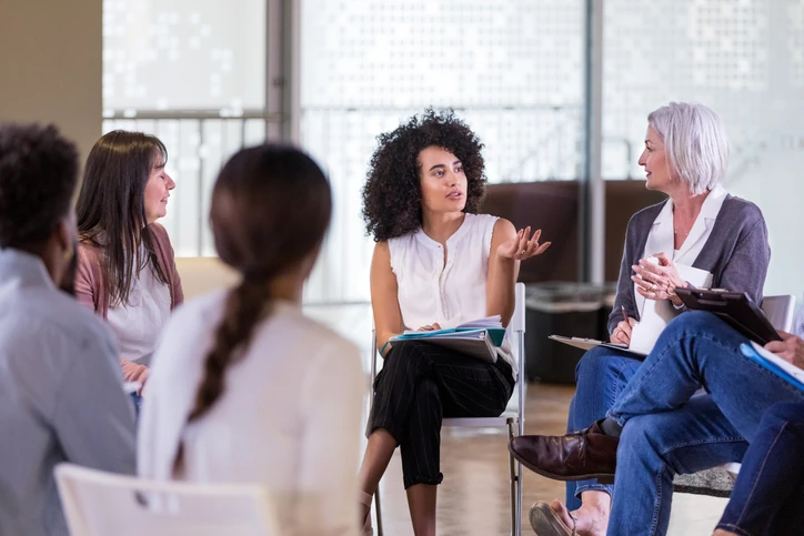 Equipe profissional diversa em reunião colaborativa discutindo ideias e estratégias em um ambiente de escritório dinâmico e inclusivo