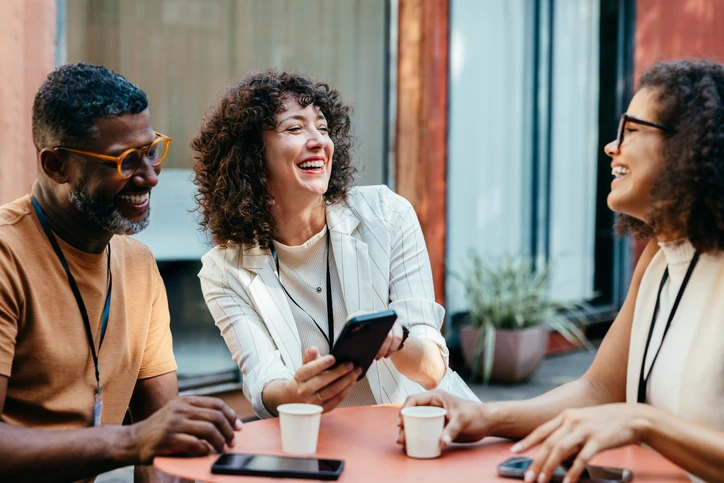 Colaboração e networking profissional em ambiente descontraído com equipe diversa durante o intervalo de trabalho