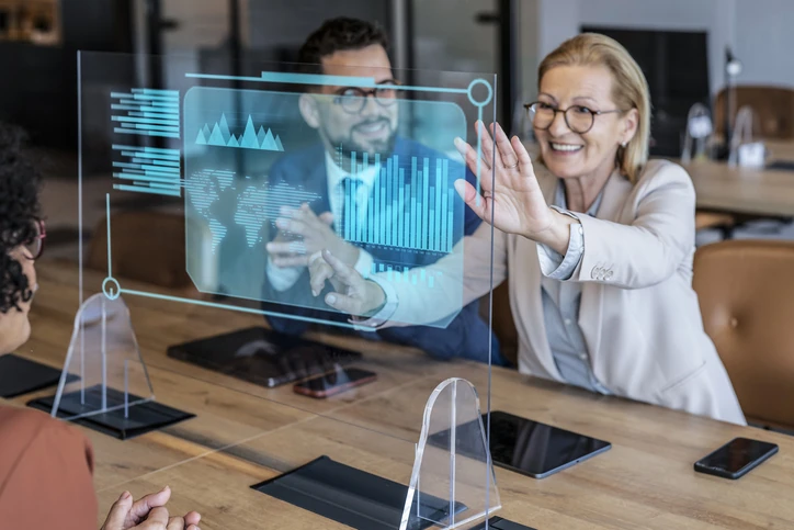 Equipe de negócios analisando dados em painel digital interativo e transparente