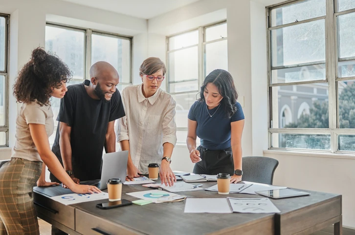 Equipe diversa colaborando em reunião de planejamento de negócios em escritório moderno