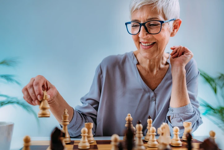 Mulher idosa concentrada jogando xadrez