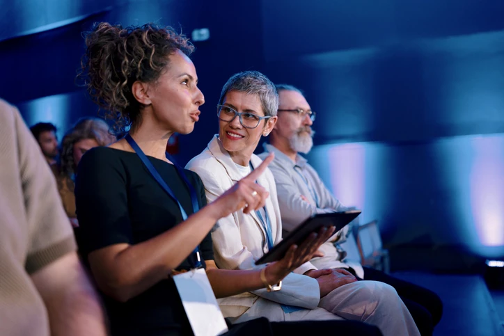 Mulheres profissionais participando de conferência corporativa ou painel de discussão