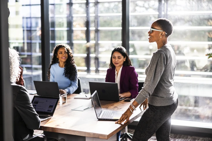 Mulher negra apresentando ideias em uma reunião de equipe corporativa em um escritório moderno