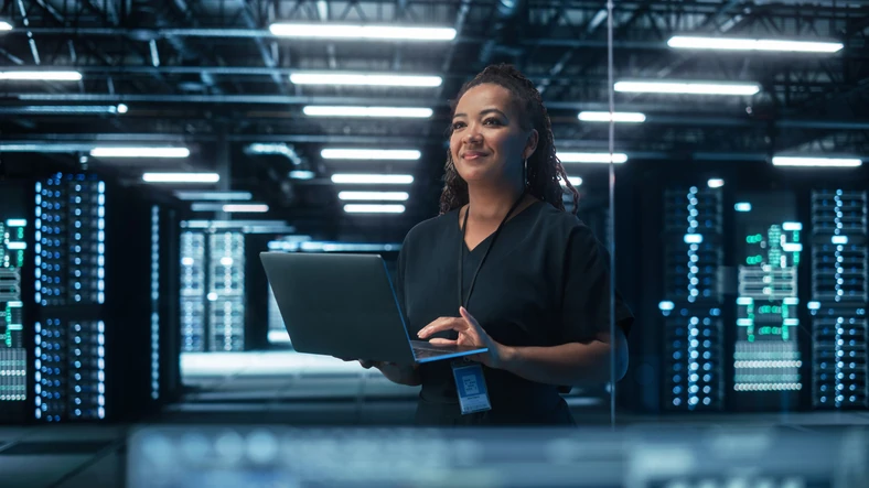 Profissional de tecnologia realizando monitoramento e manutenção de infraestrutura de datacenter moderno Especialista em TI trabalhando em um servidor de dados com um notebook