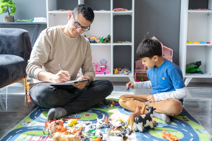 Psicólogo realizando atendimento infantil com brinquedos em um consultório
