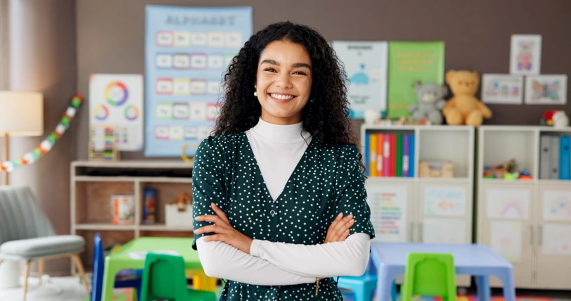 Professora sorridente em uma sala de aula colorida de educação infantil