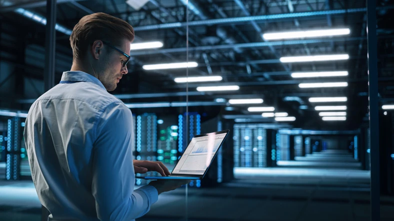 Especialista em tecnologia monitorando infraestrutura de servidores em um data center moderno para garantir a segurança e performance dos sistemas
