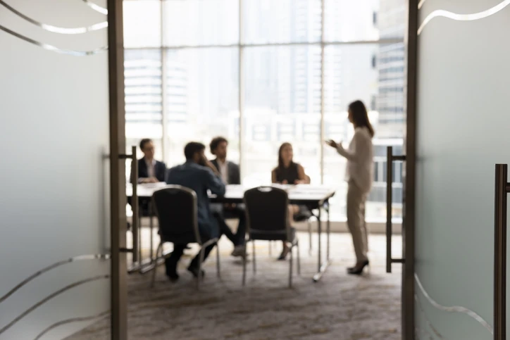 Visão geral de uma equipe corporativa em uma reunião de trabalho colaborativa dentro de uma sala de conferências moderna