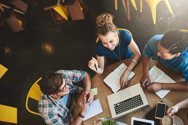 Estudantes universitários colaborando em grupo para realizar atividades acadêmicas e projetos de pesquisa acadêmica