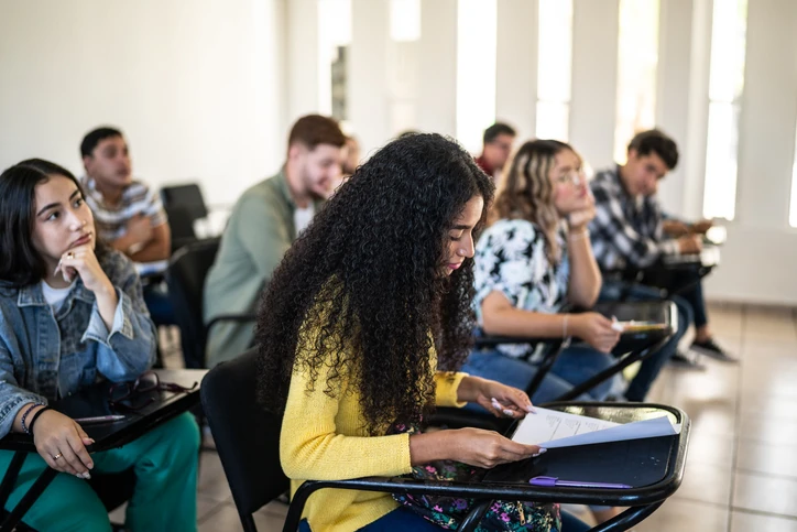 Grupo de estudantes universitários acompanhando uma aula prática em ambiente acadêmico moderno