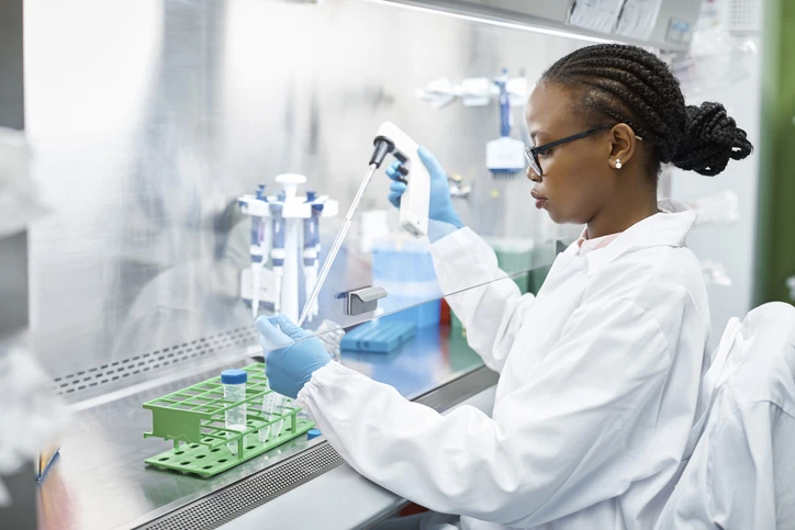 Pesquisadora científica trabalhando em laboratório de biotecnologia utilizando equipamentos de precisão para análise