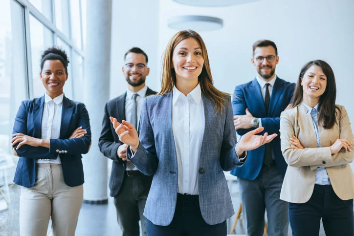 Equipe de profissionais de negócios diversos posando juntos e sorrindo em um ambiente de escritório corporativo moderno para representar sucesso e colaboração Equipe de profissionais diversos sorridentes em um ambiente de escritório moderno