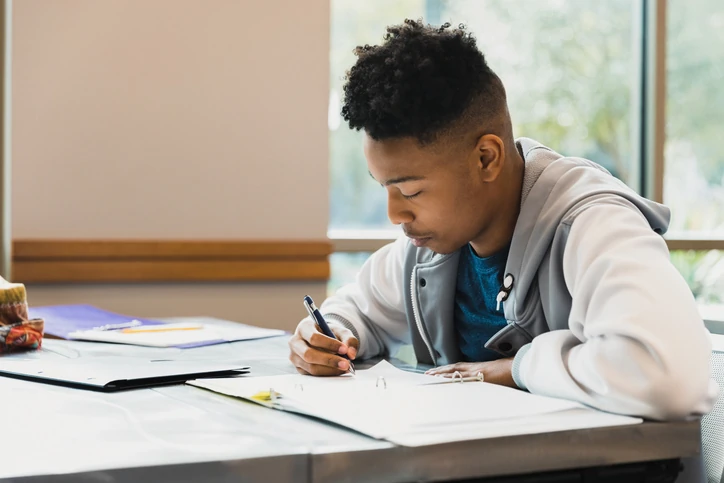 Estudante dedicado realizando suas atividades acadêmicas e estudando para provas em um ambiente escolar