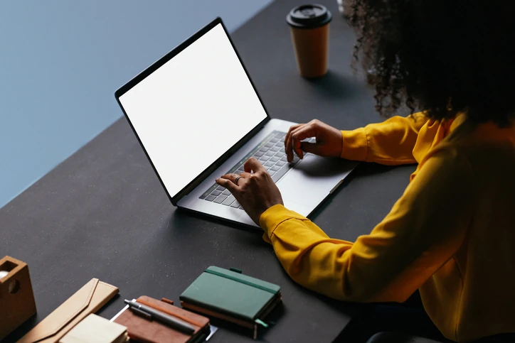 Profissional utilizando notebook com tela editável para design ou estudos em um ambiente de trabalho produtivo