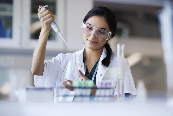 Cientista realizando pesquisa em laboratório com pipeta e frasco