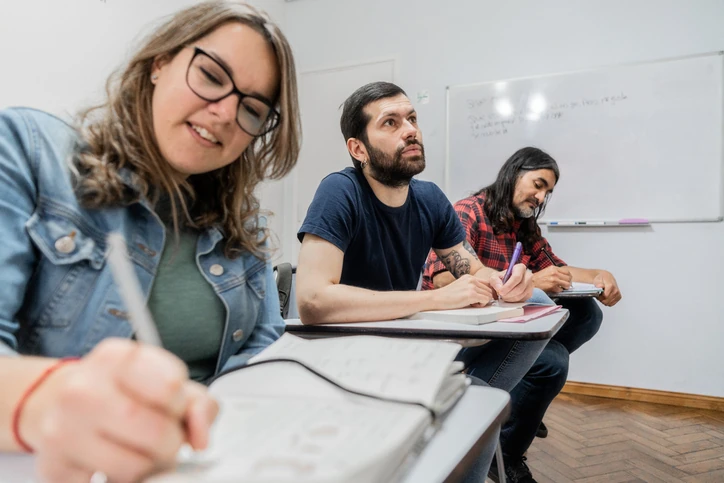 Estudantes em sala de aula fazendo anotações em cadernos