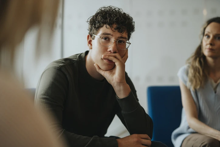 Jovem estudante atento participando de uma discussão em grupo ou dinâmica de sala de aula