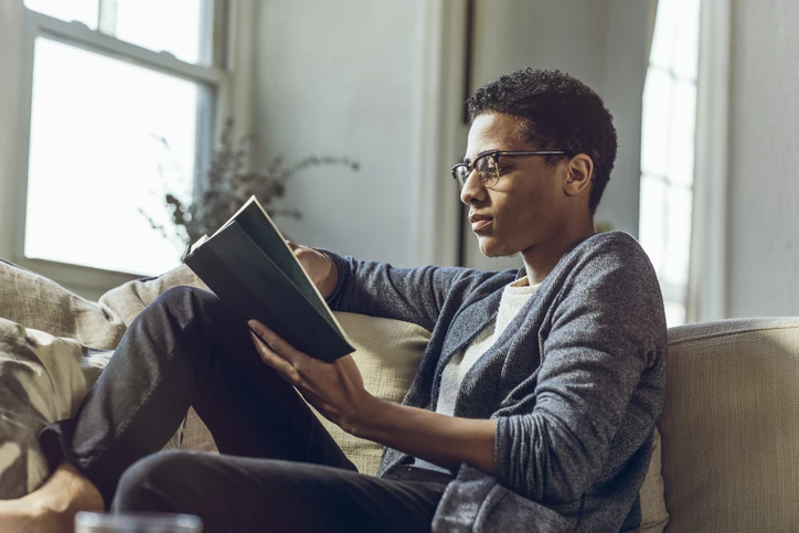 https://estaticos.animaeducacao.com.br/medias/20260511181437/GettyImages-1406476377.webp Estudante dedicado lendo um livro em um ambiente confortável para manter o foco nos estudos e aprendizado