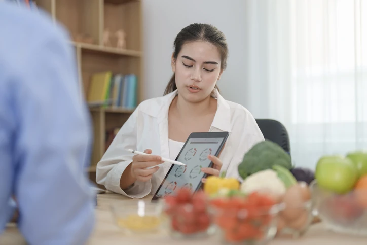 Nutricionista profissional orientando paciente com plano alimentar personalizado em consultório clínico
