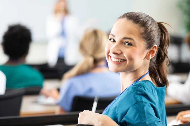 Estudante de enfermagem sorridente durante aula em sala de treinamento médico