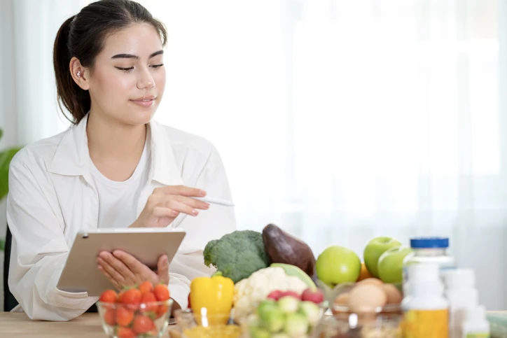 Nutricionista avaliando plano alimentar saudável com alimentos frescos e suplementos em consultório ou ambiente doméstico