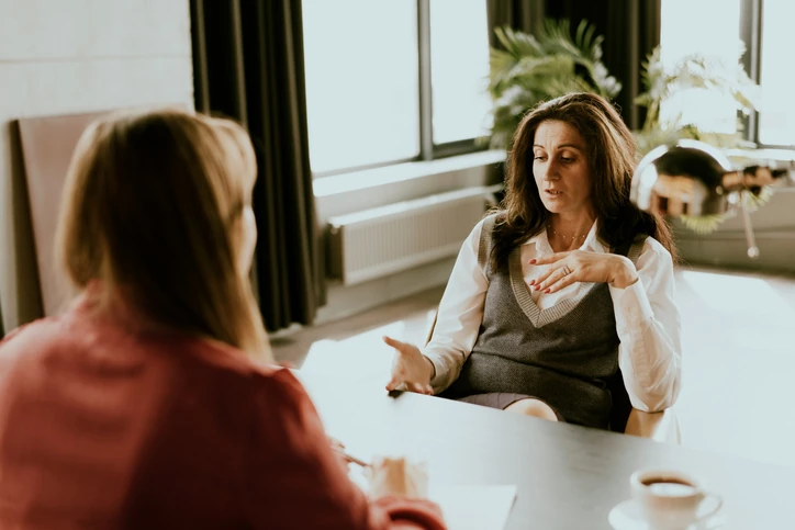 Mulheres em reunião de negócios discutindo estratégias profissionais em um ambiente de escritório colaborativo e iluminado Duas mulheres profissionais em uma reunião de trabalho em um escritório moderno