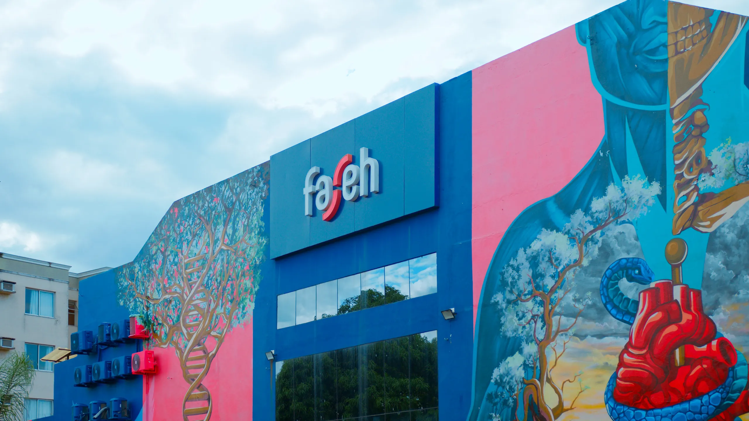 Fachada da Faseh com logotipo da instituição e mural artístico colorido na entrada do campus.