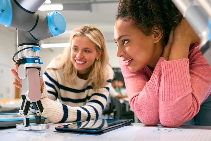 Jovem estudante sorrindo enquanto utiliza equipamentos de tecnologia em um laboratório moderno do Centro Universitário UniCuritiba.