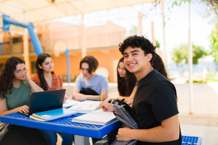 Estudantes calculando o peso das notas do ENEM para ingresso na UNIFACS. Grupo de jovens simulando o cálculo da nota do ENEM no notebook para entrar na universidade na Bahia.