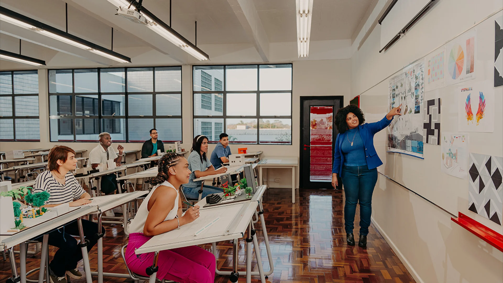 Professora de arquitetura apresentando projeto em sala de aula para alunos