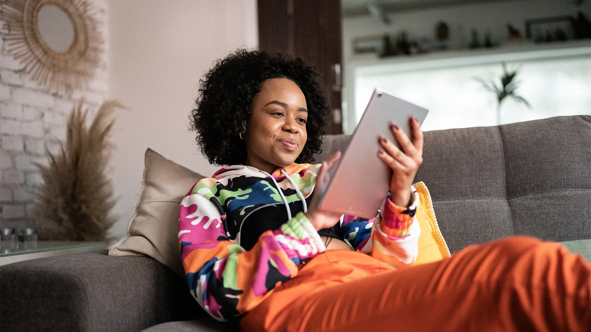 Estudante jovem utilizando tablet para atividades digitais e estudos online em ambiente confortável