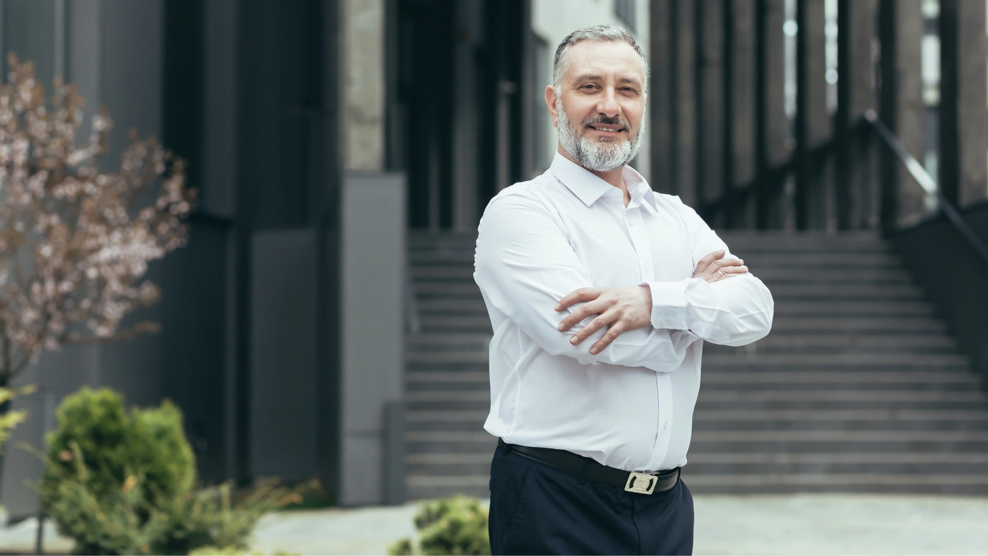 Executivo experiente e profissional sorrindo em um ambiente corporativo moderno, transmitindo liderança e sucesso nos negócios