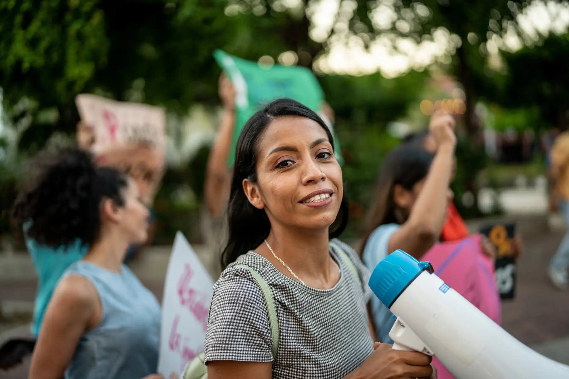 Mulher sorridente segurando um megafone durante uma manifestação ou protesto social