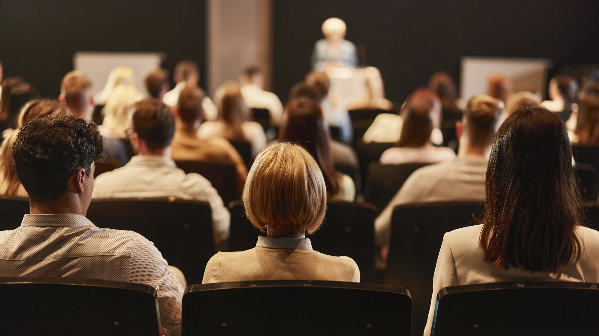 Público assistindo a uma palestra ou evento acadêmico em auditório