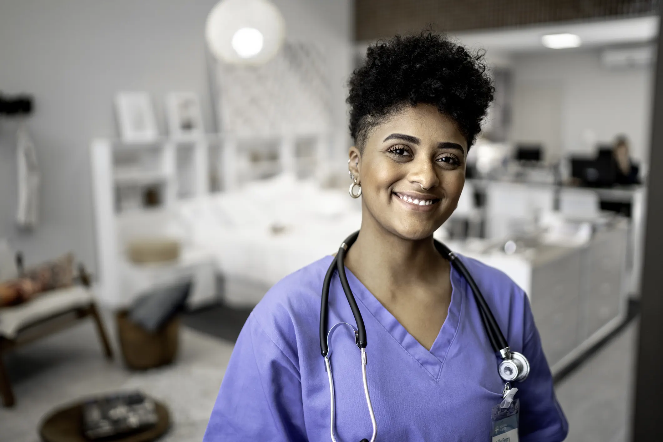 Enfermeira profissional sorridente com estetoscópio pronta para atendimento em ambiente hospitalar moderno