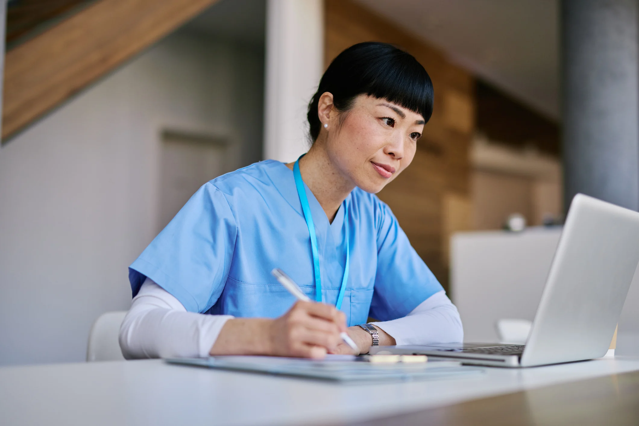 Profissional de saúde utilizando tecnologia e realizando anotações em ambiente de trabalho hospitalar ou clínico