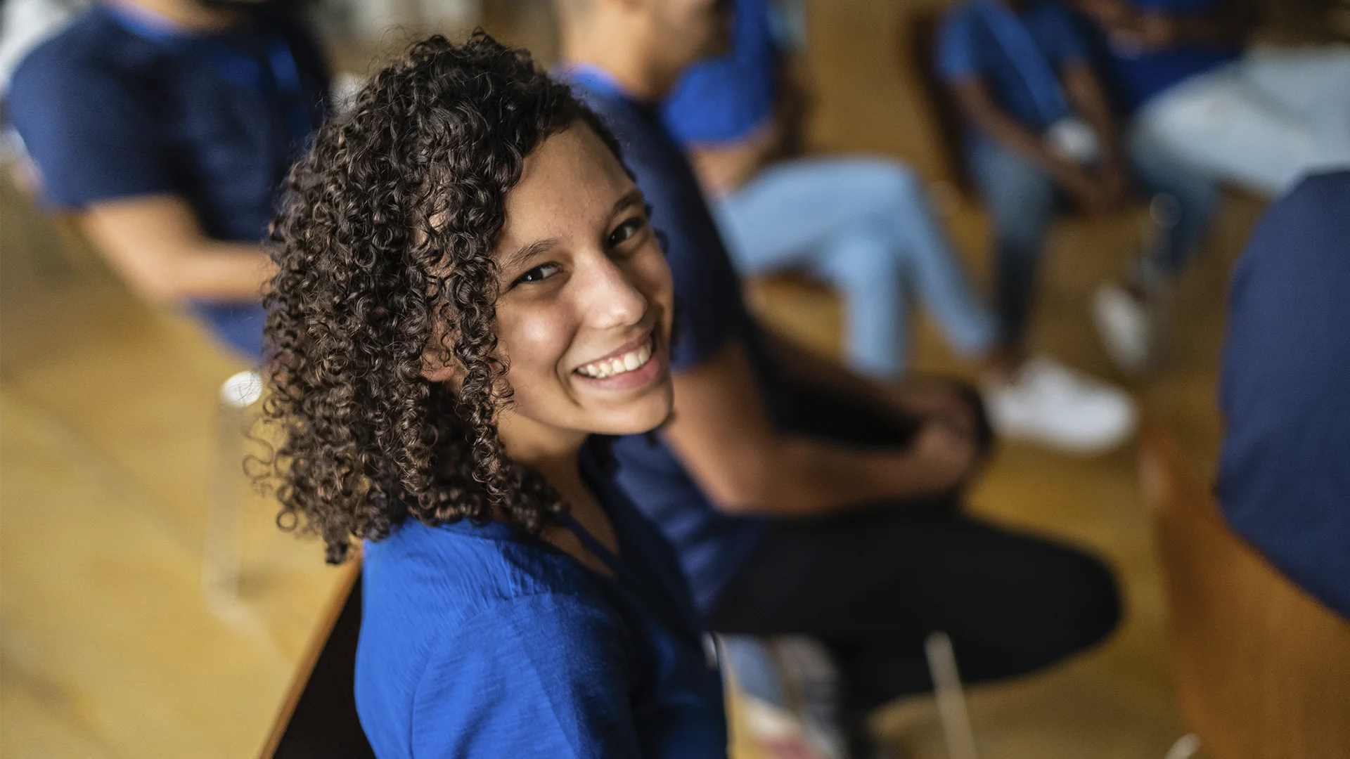 Jovem estudante sorrindo durante atividade em grupo na faculdade