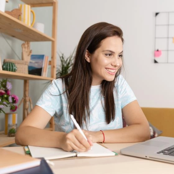 Estudante universitária concentrada e feliz realizando pesquisas acadêmicas no computador durante estudos em casa