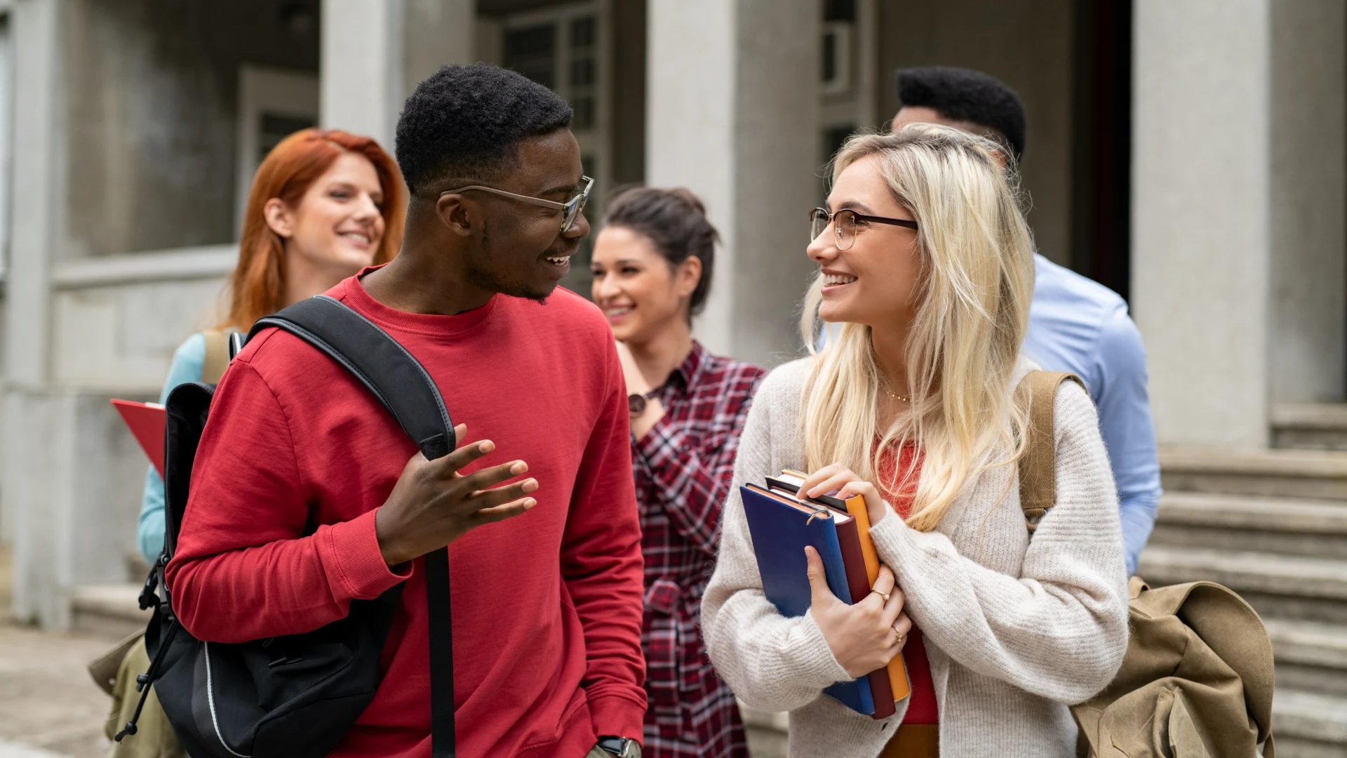 Estudantes universitários felizes conversando e estudando juntos no campus da faculdade