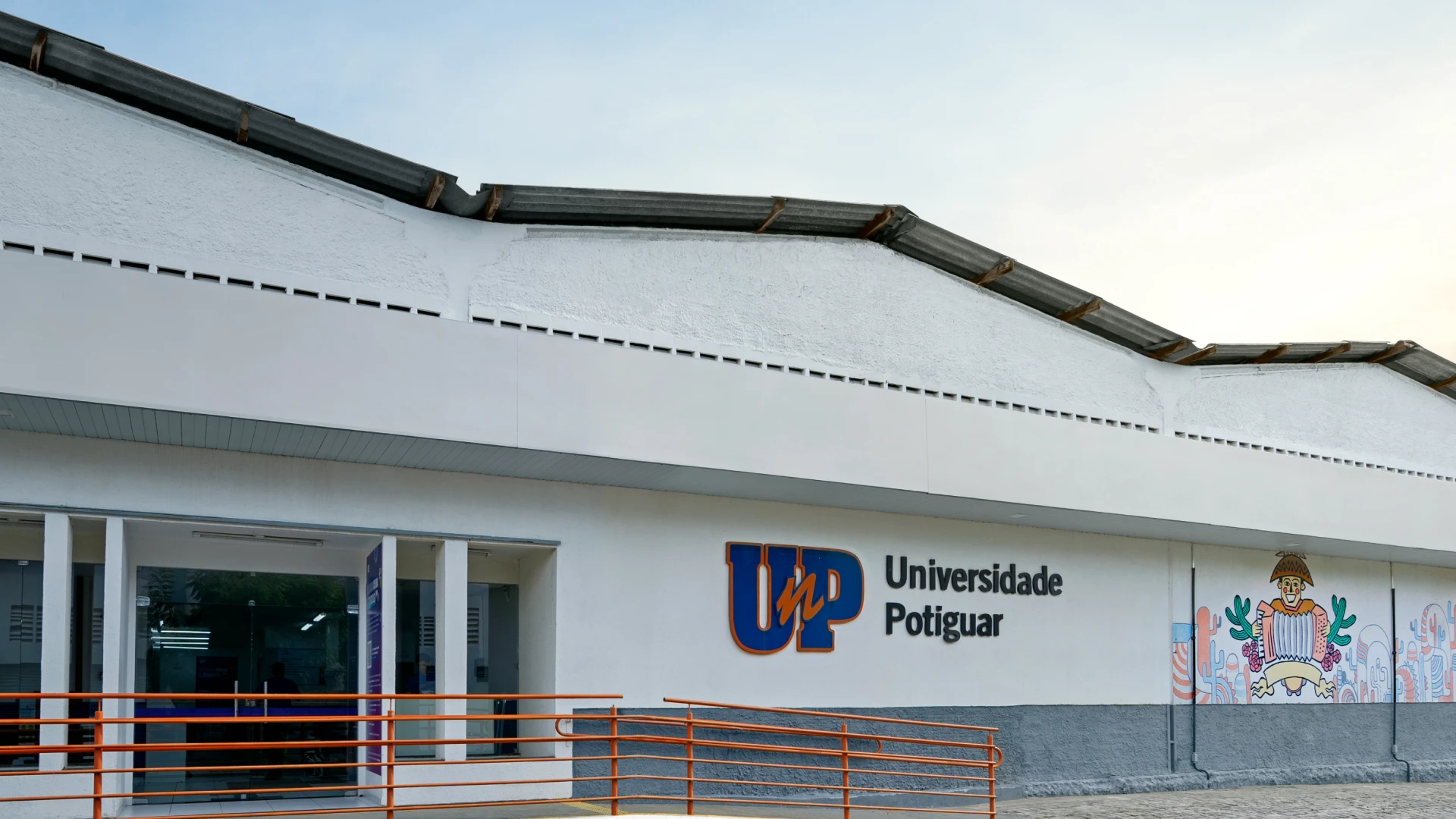 Fachada do campus da Universidade Potiguar (UnP) com logo e mural artístico