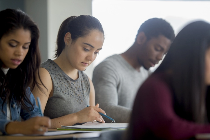 Estudantes universitários focados em suas atividades acadêmicas dentro de uma sala de aula moderna durante o período de estudos