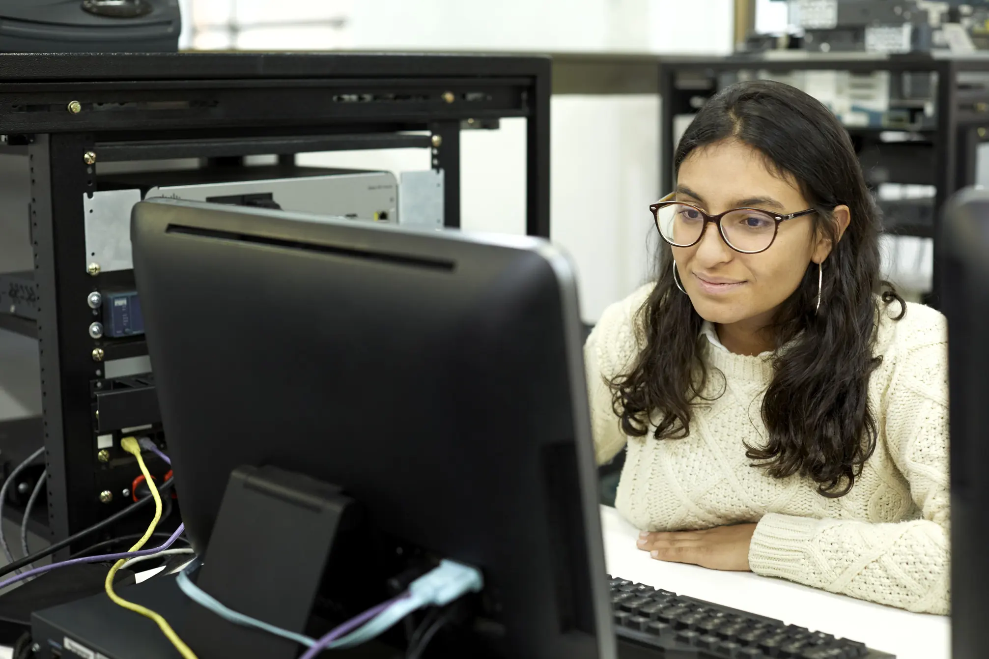 Estudante de tecnologia trabalhando em um computador em laboratório de redes