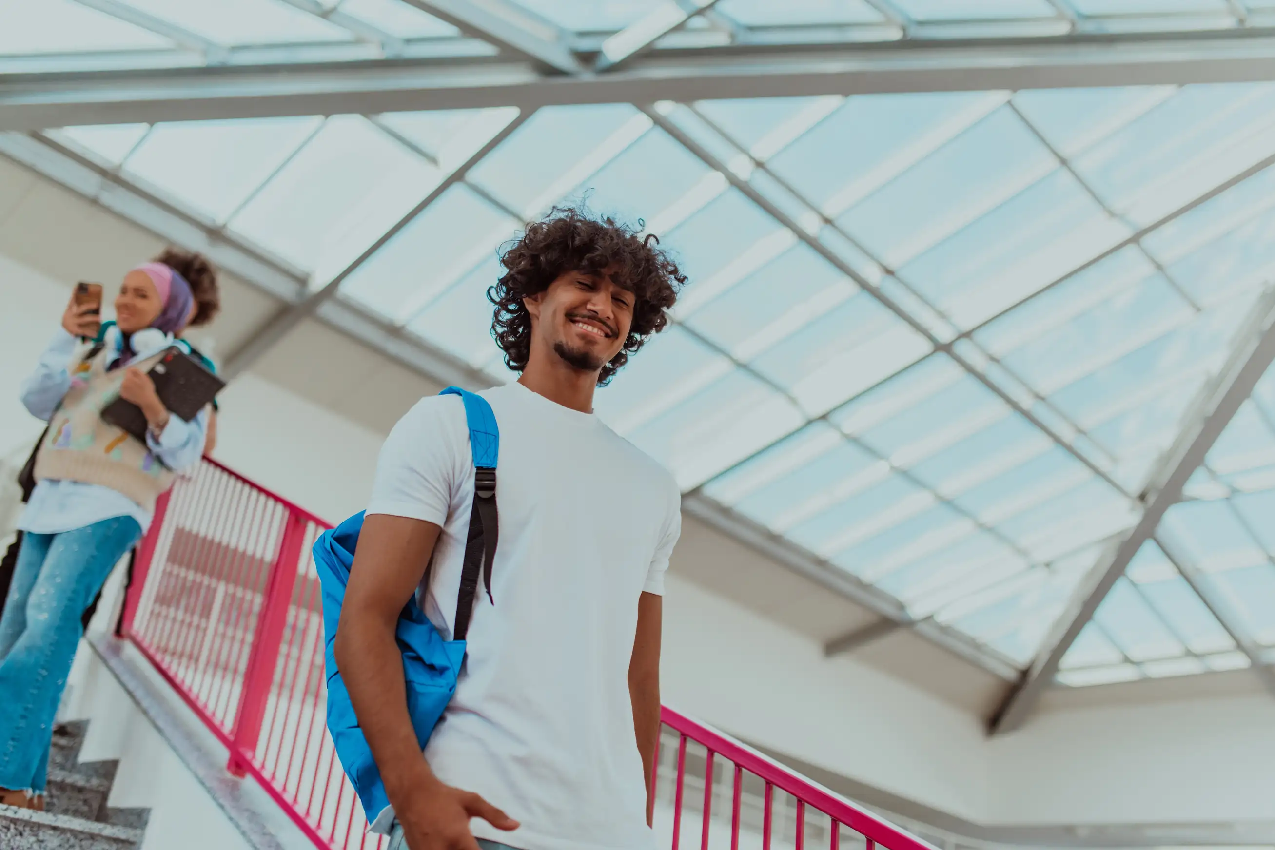Estudante universitário jovem e feliz caminhando em um campus moderno com arquitetura contemporânea
