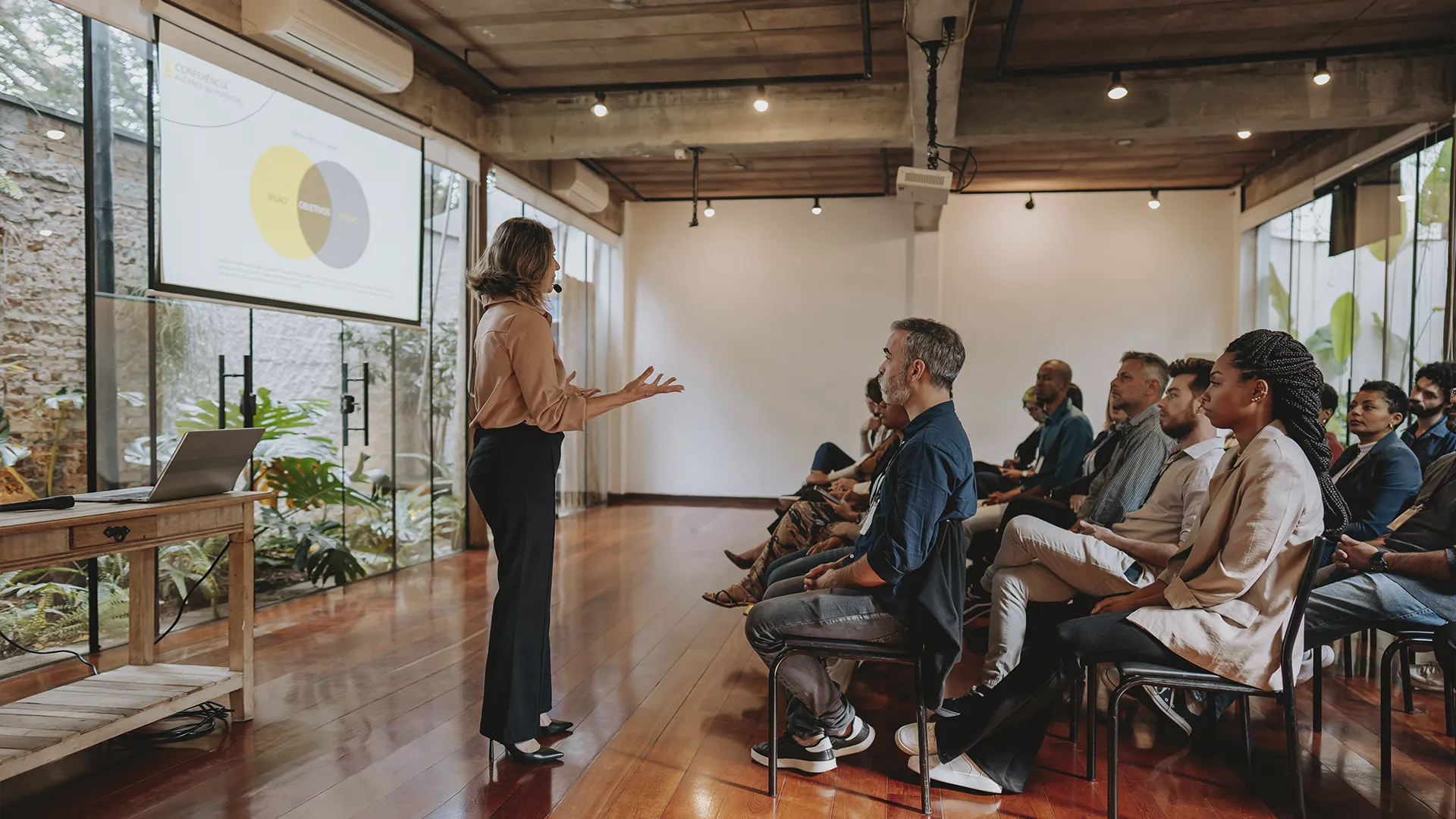Palestrante apresentando conferência para público em sala corporativa moderna