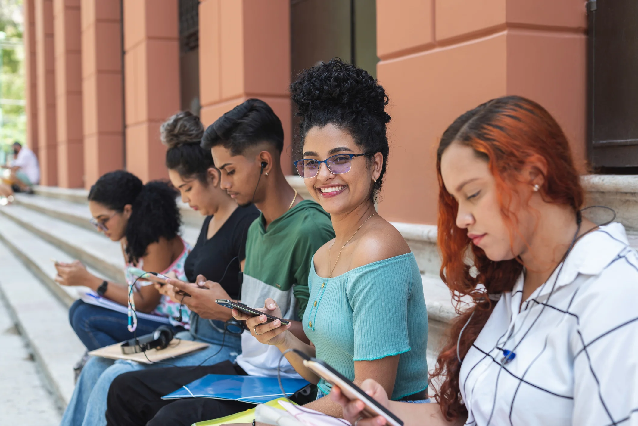 Estudantes universitários conectados e usando tecnologia durante o intervalo de aulas no ambiente acadêmico